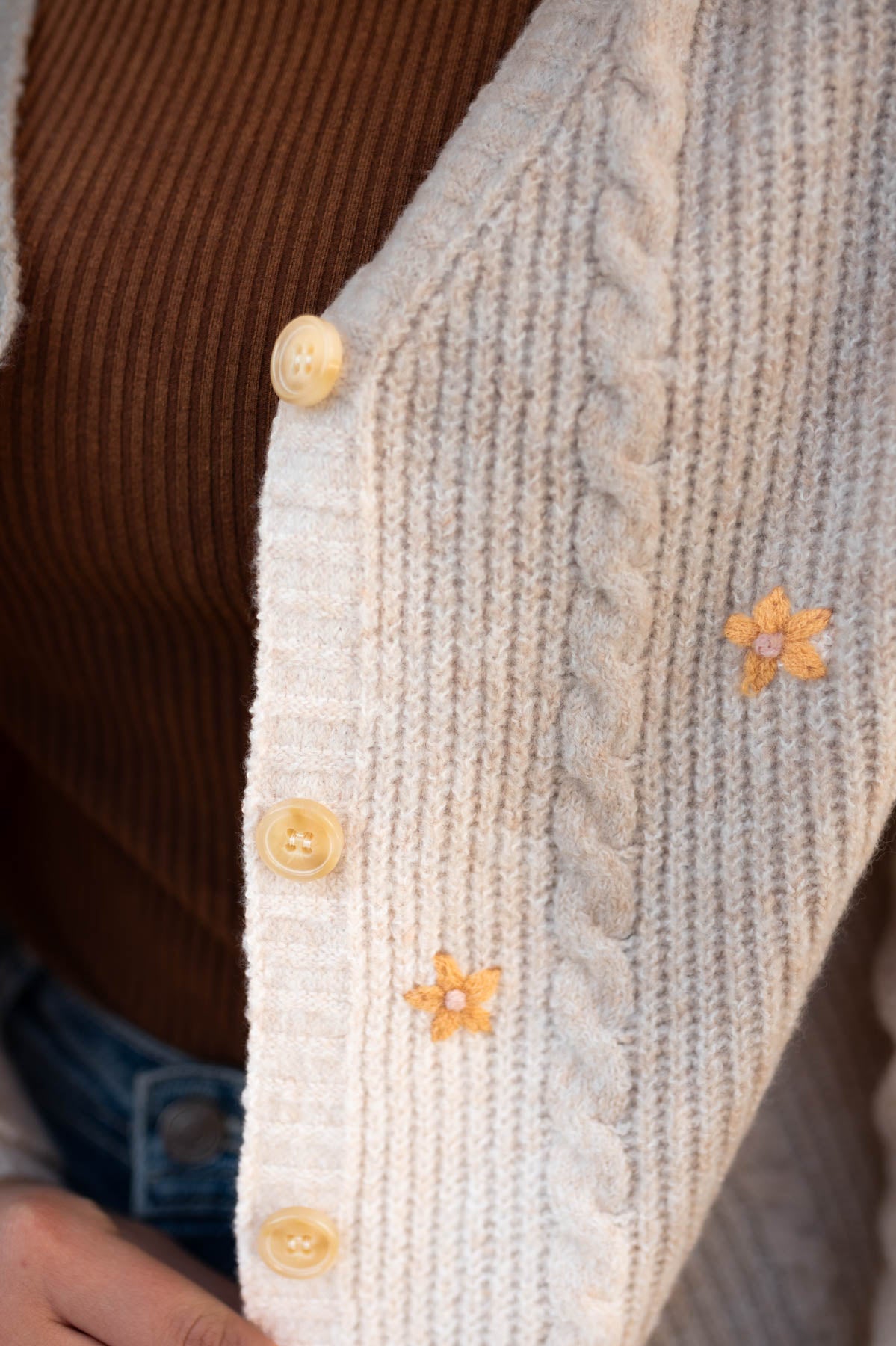 Button detail on a cream cardigan