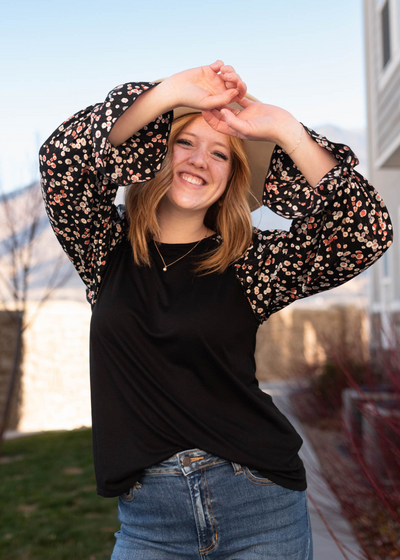Front view of the black pattern sleeve top with floral sleeves