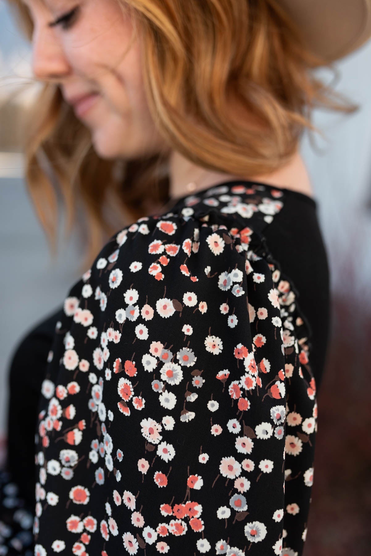 Close up of the floral sleeve on a black pattern sleeve top
