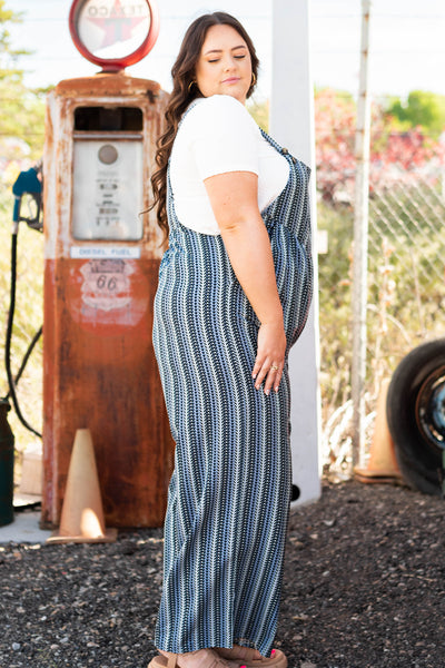Side view of a plus size midnight blue jumpsuit with pocket