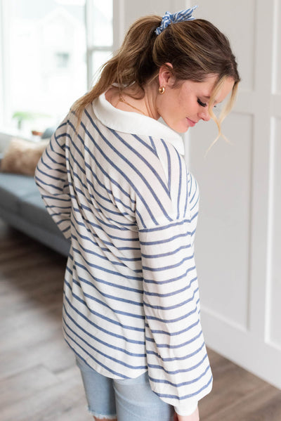 Side view of a navy striped top with a collar