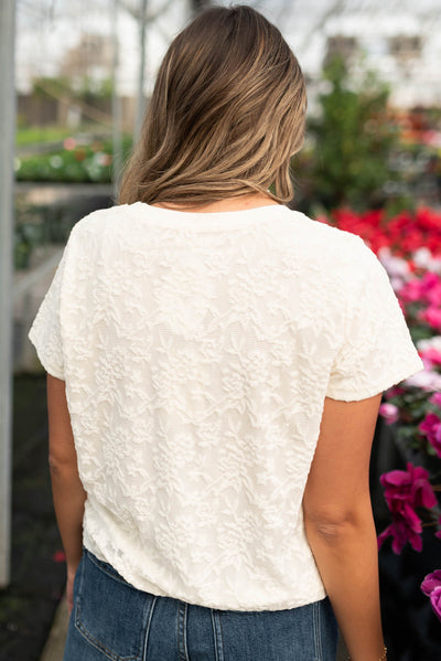 Back view of the ivory floral textured top