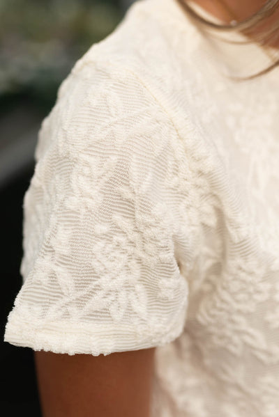 Close up of the floral texture on the ivory floral textured top