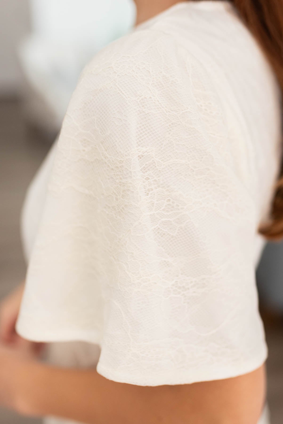 The sleeve and fabric on the white lace dress