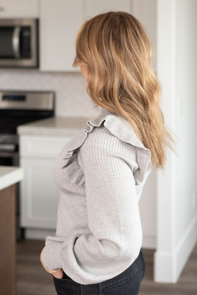 Side view of the heather grey turtleneck sweater