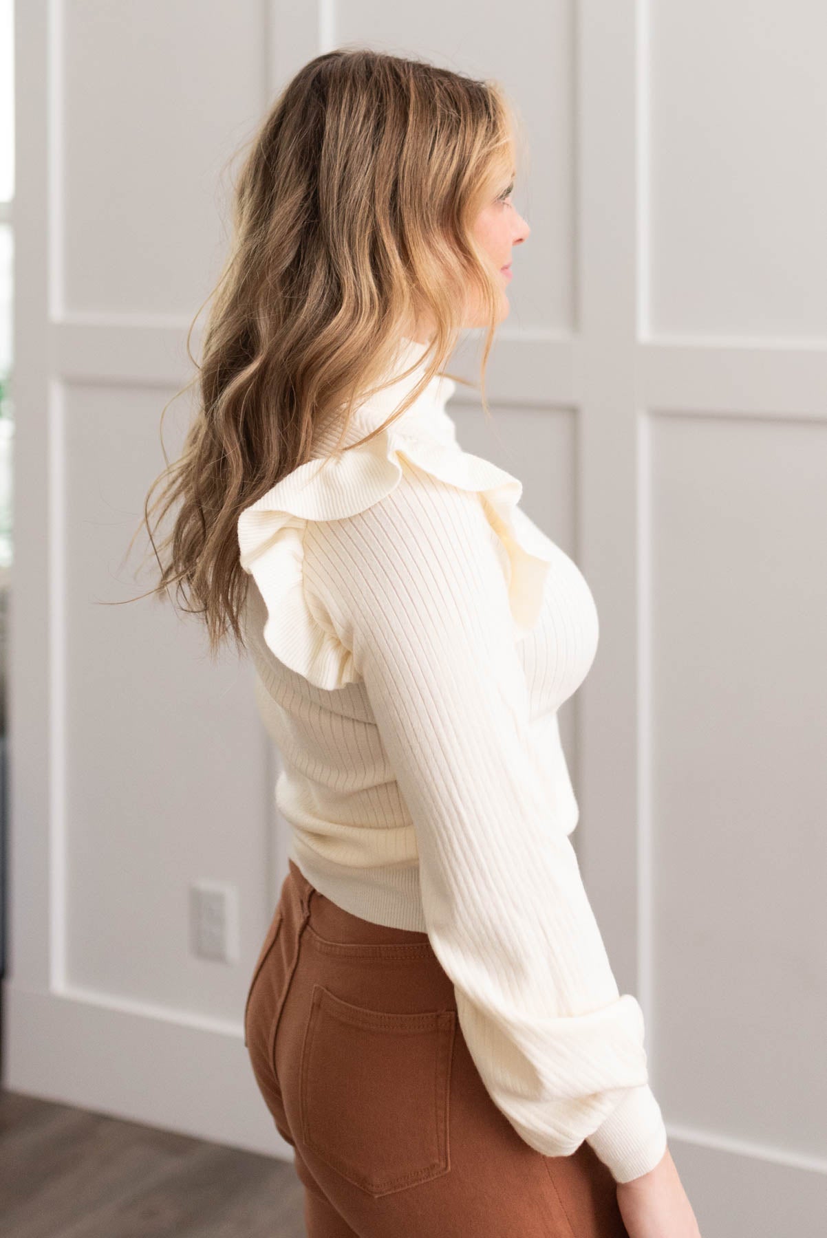 Side view of the ivory ruffle turtleneck sweater