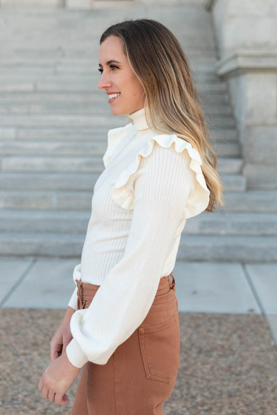 Side view of the ivory ruffle turtleneck sweater