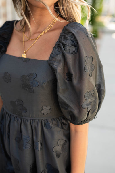 Bodice and sleeve of a black floral dress