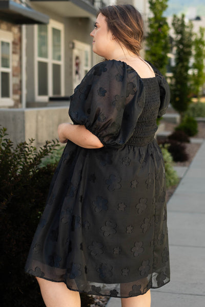 Side view of a plus size black floral dress