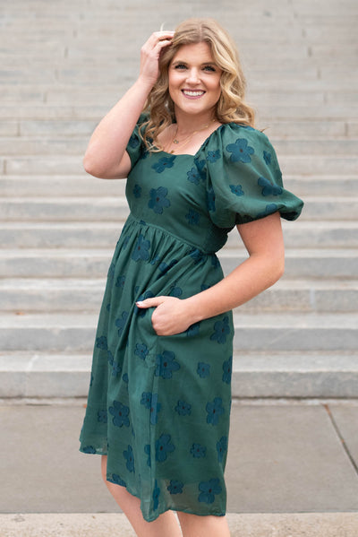 Side view of a hunter green floral dress