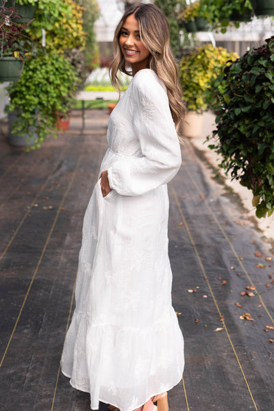 Side view of the embroidered white dress with pockets