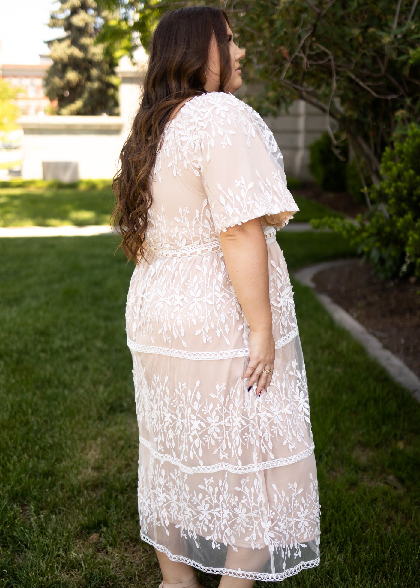 Side view of a plus size ivory lace dress with short sleeves