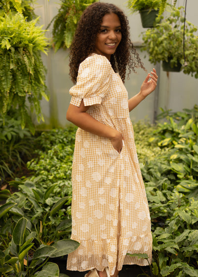 Side view of a small mustard dress with pockets