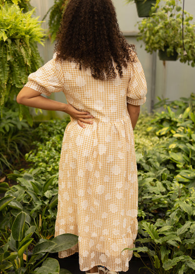 Back view of a small mustard dress with white flowers