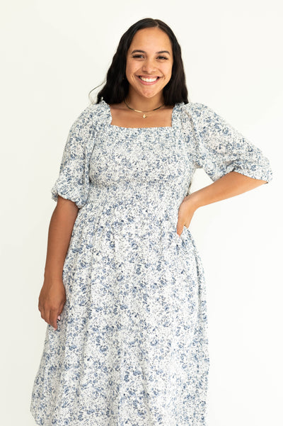 Front view of a Short sleeve blue floral plus size dress with smocked bodice.