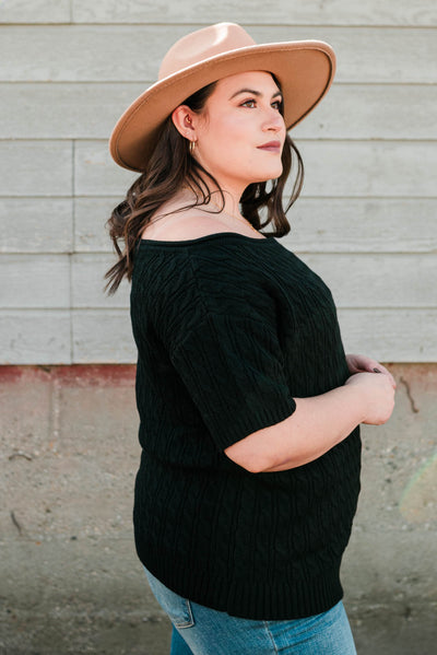 Side view of a plus size black knit top