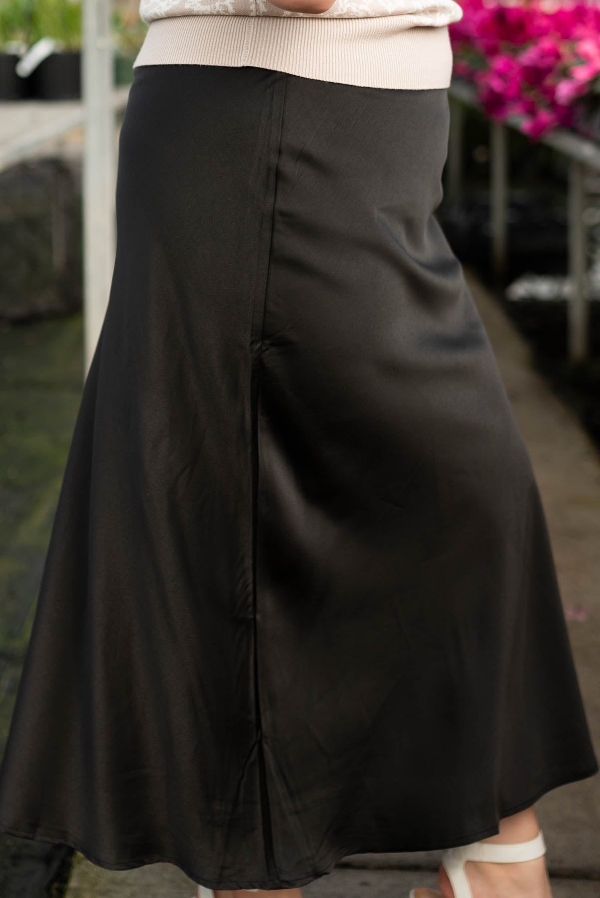Side view of the plus size black satin midi skirt