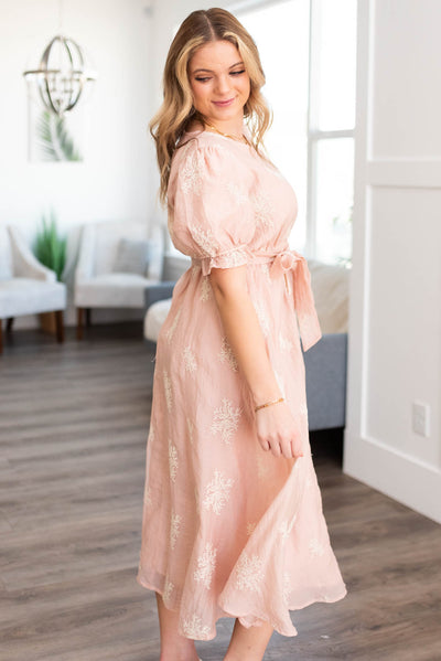 Side view of a short sleeve blush dress that ties at the waist