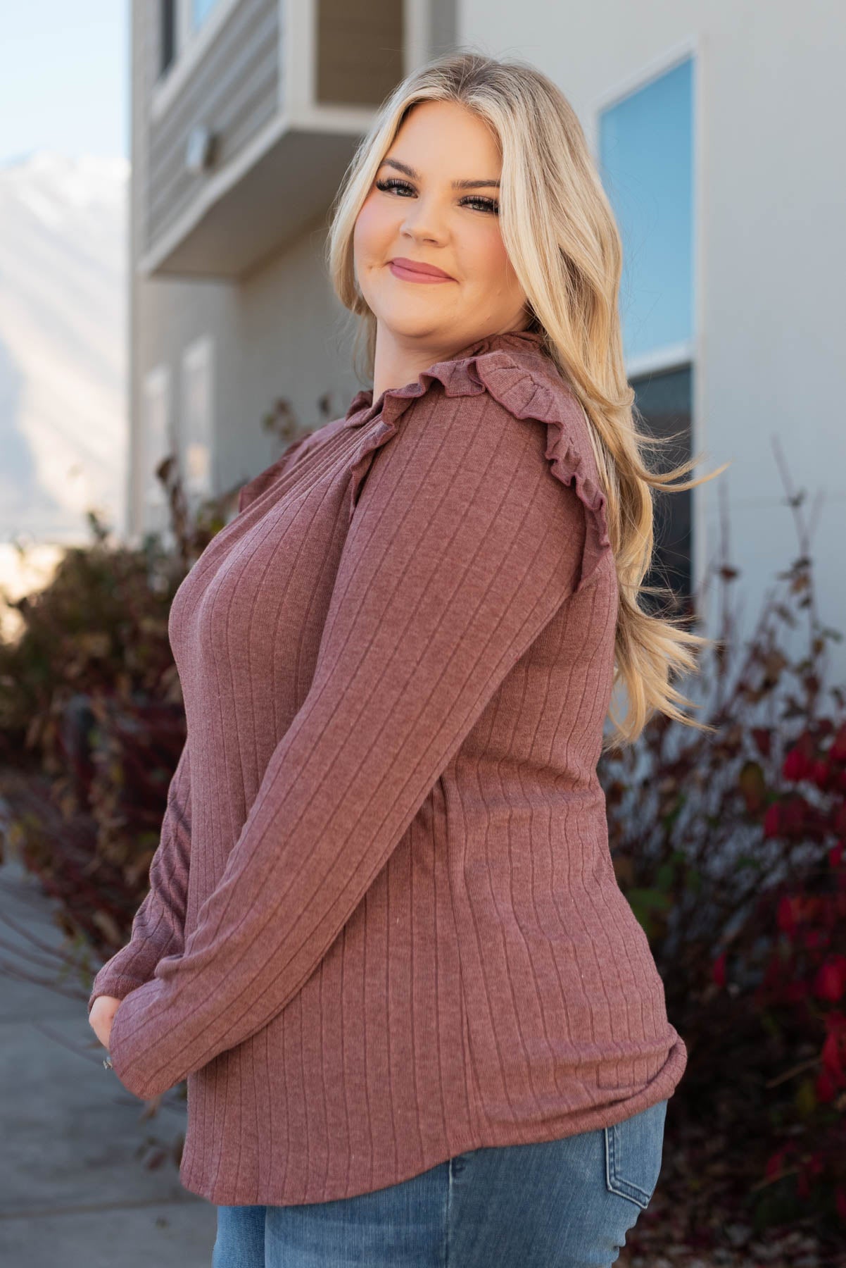Side view of a plus size burgundy ruffle long sleeve top