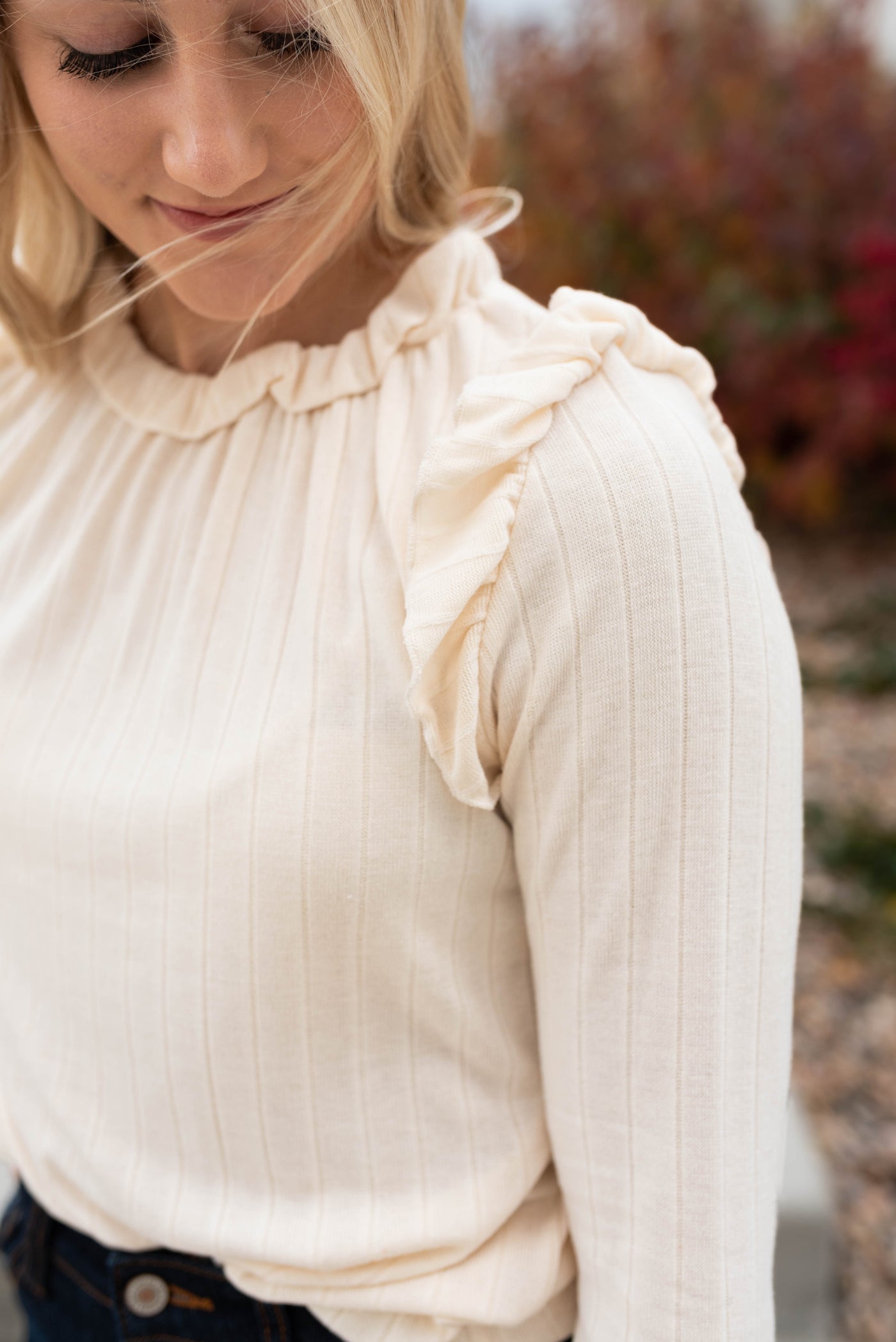 Close up of the ruffles on the cream ruffle long sleeve top