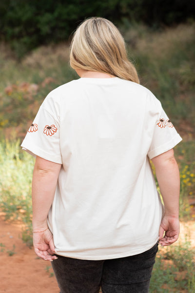 Back view of a plus size ivory floral top