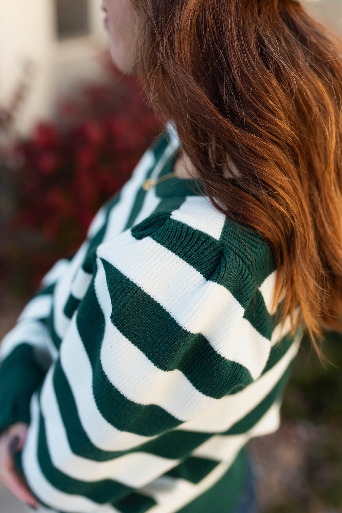 Close up of the gathered sleeve on the hunter green striped sweater