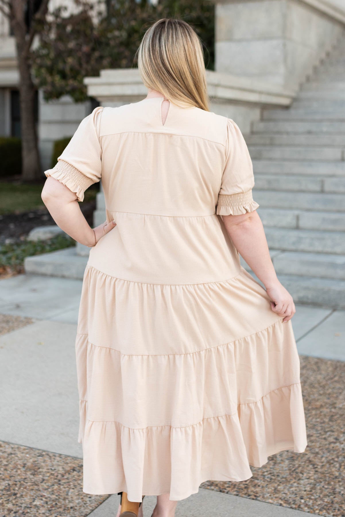 Back view of a plus size tiered cream dress
