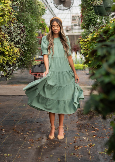 Front view of the tiered green dress with elastic on the sleeves