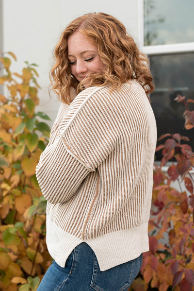 Side view of the long sleeve cream knit sweater