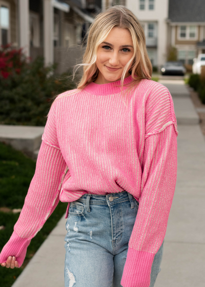 Pink knit sweater with dark pink cuffs and neck