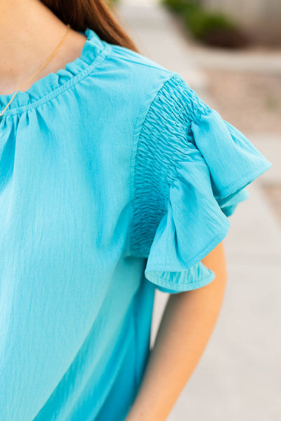 Smocking on the sleeve of the turquoise ruffle blouse
