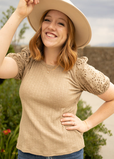 Front view of a short sleeve taupe top with eyelet sleeves