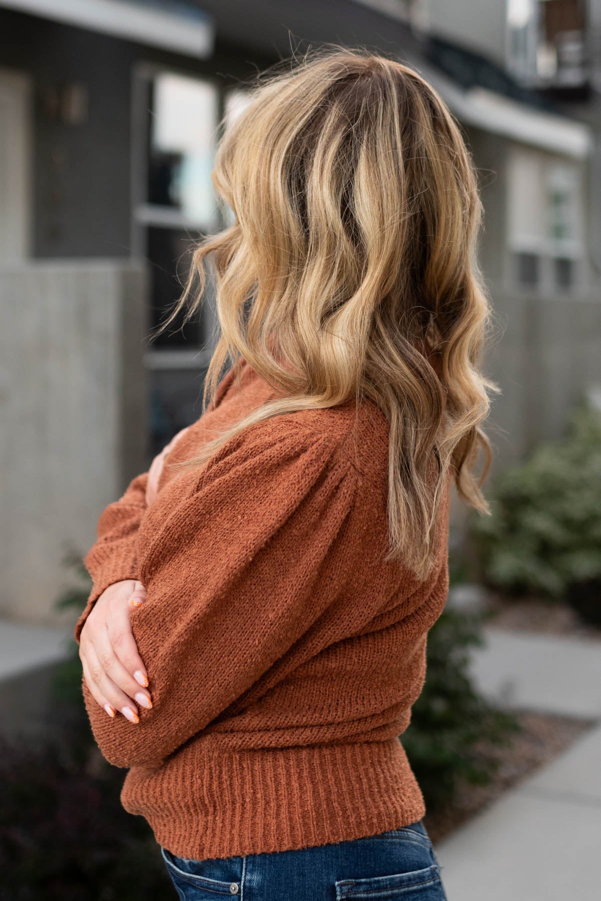 Side view of a camel knit sweater