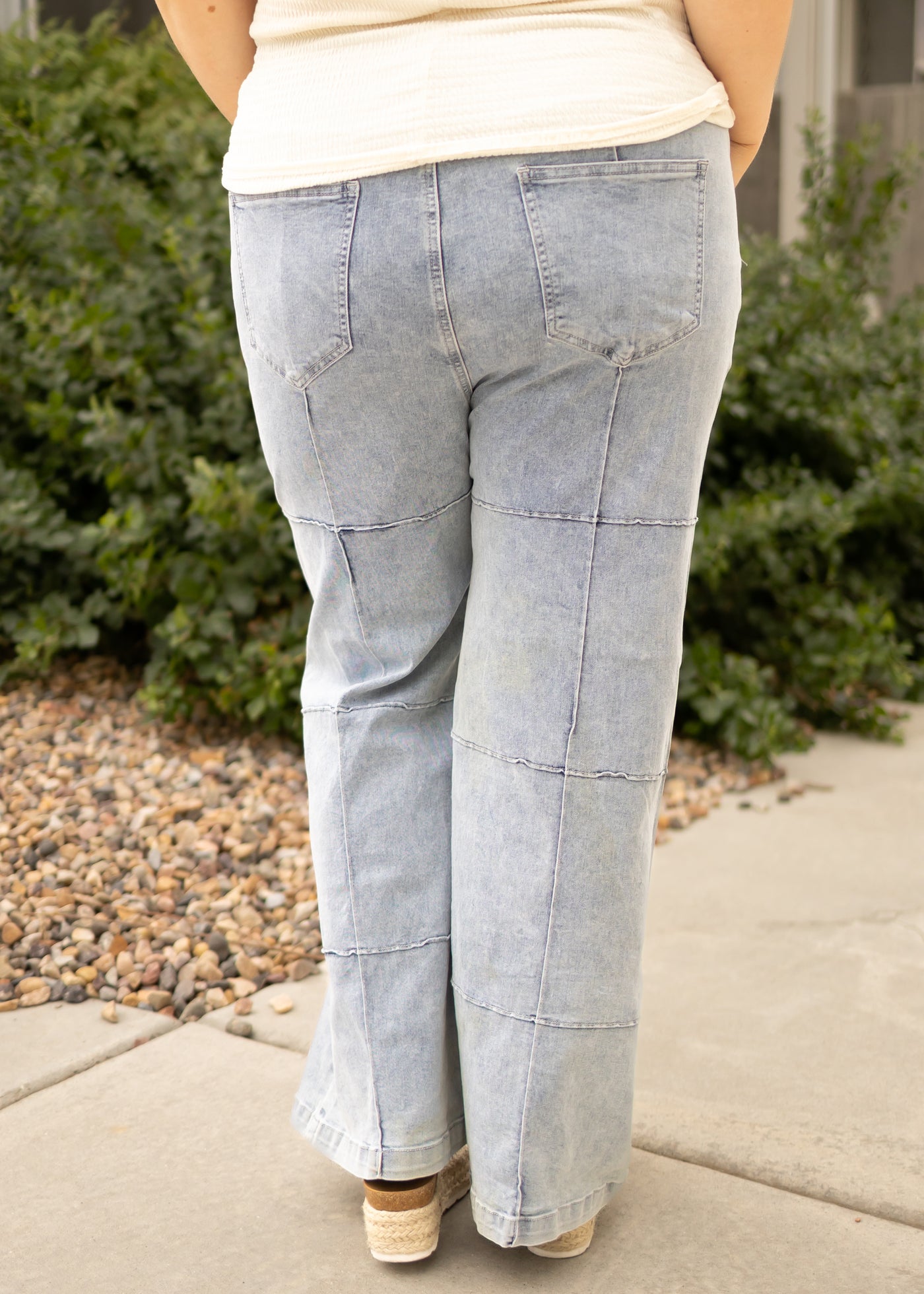 Back view of plus size light denim jeans with outside patchwork stitching