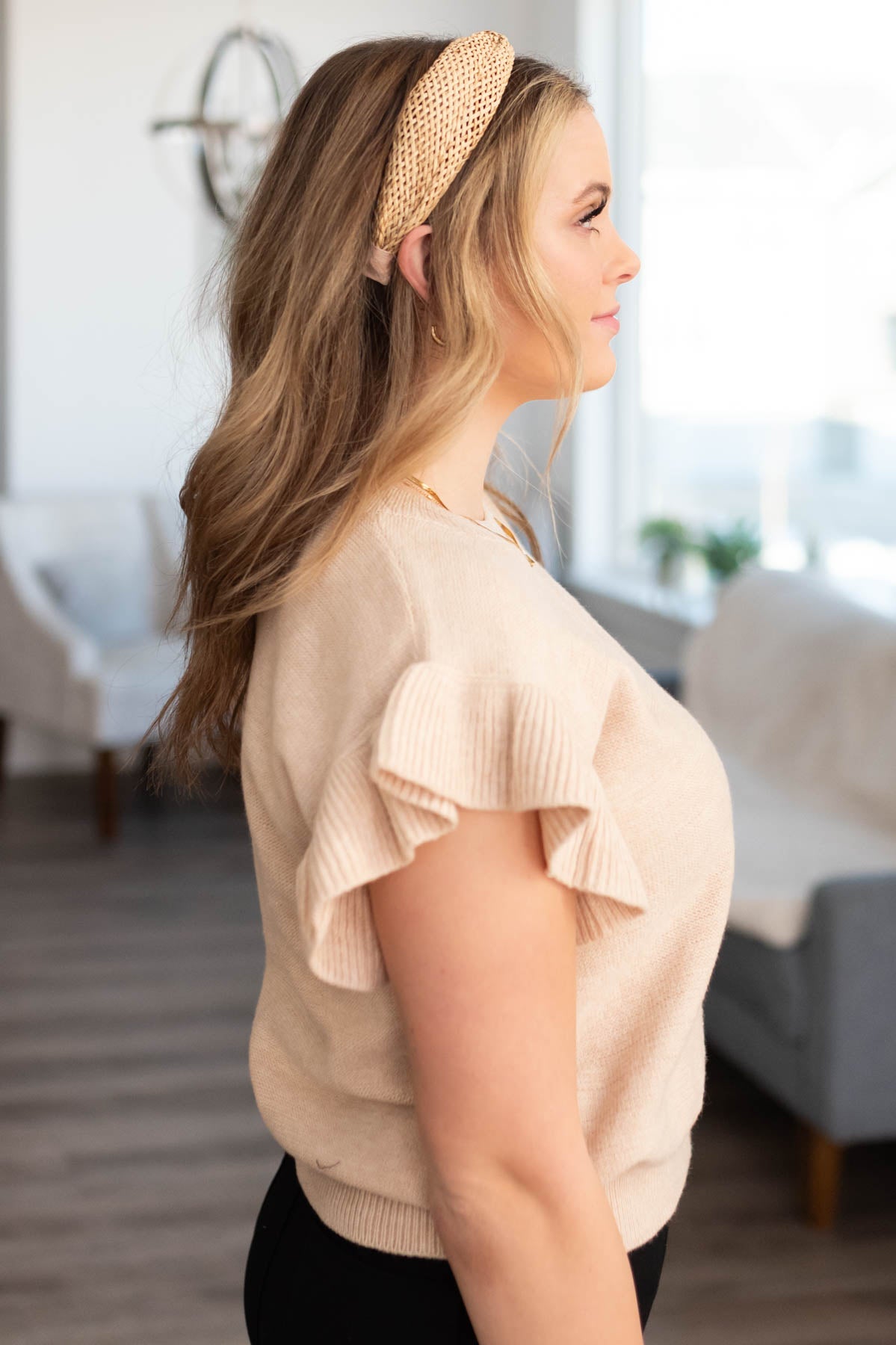 Side view of the beige ruffle sleeve knit top