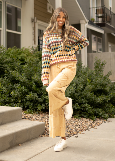 Multi sweater with camel pants that have pockets on the side that are sold separately