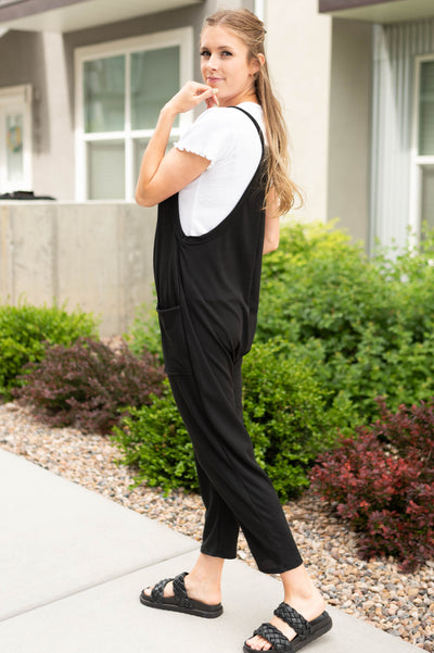 Side view of a black jumpsuit with pockets