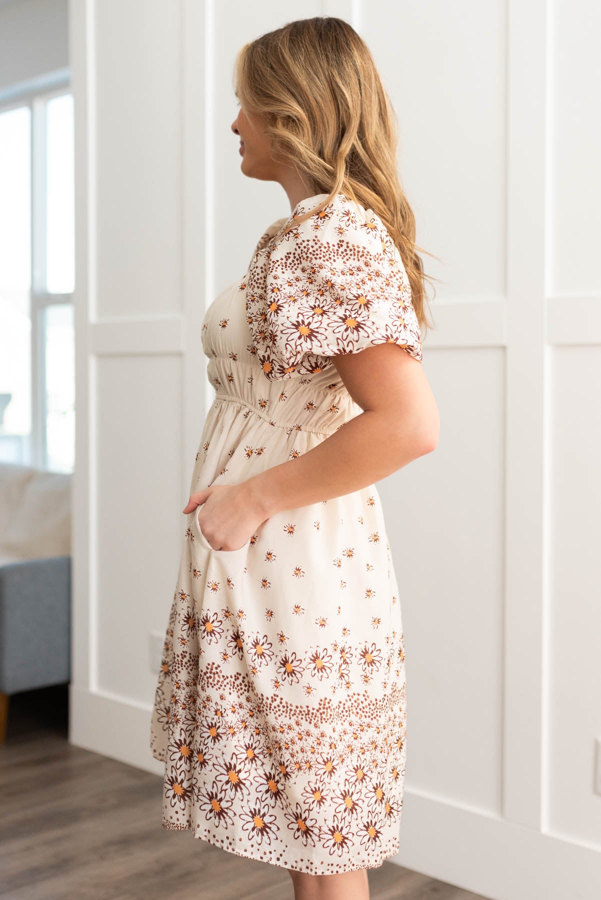 Side view of the beige daisy dress with pockets
