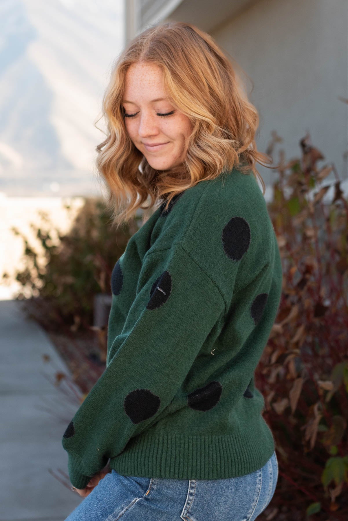 Side view of a green poka dot sweater