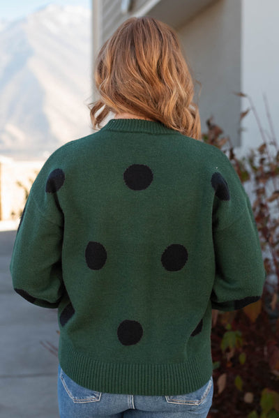 Back view of a green poka dot sweater
