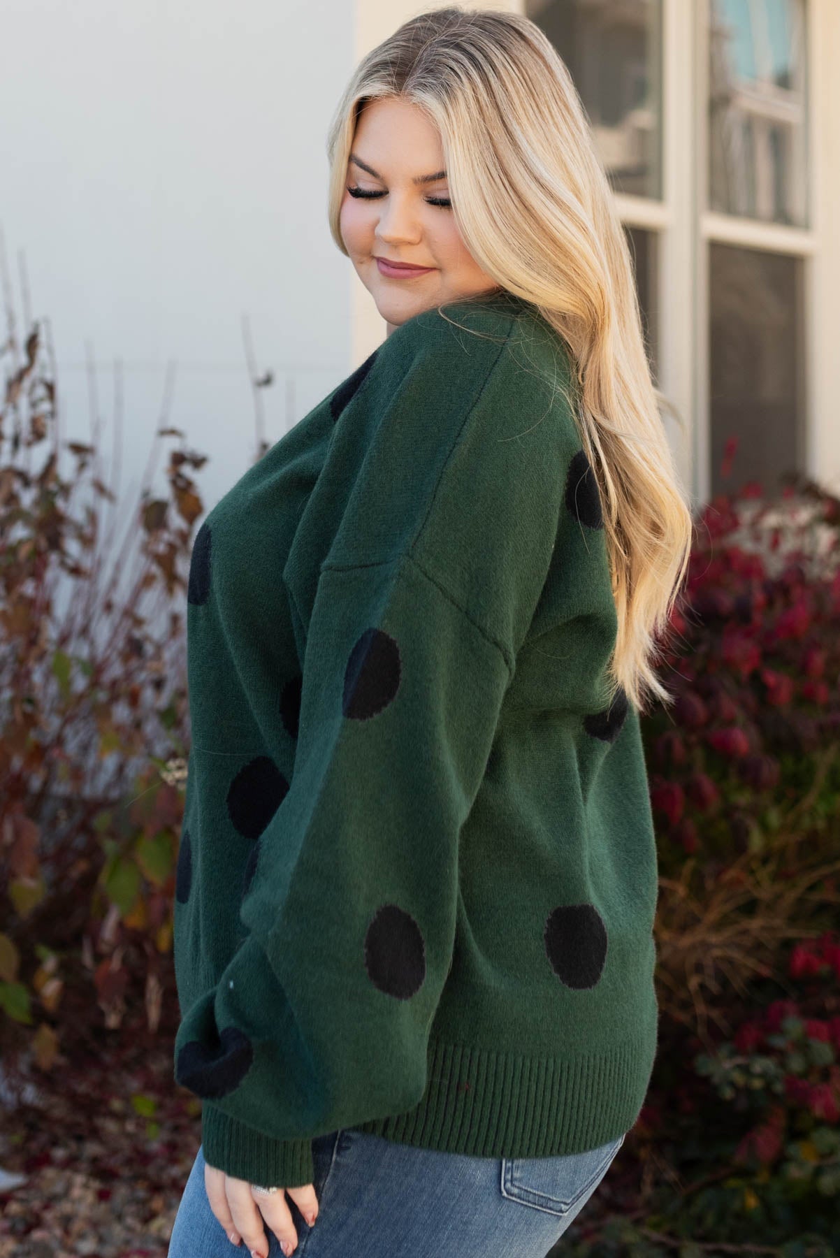 Side view of the plus size green poka dot sweater