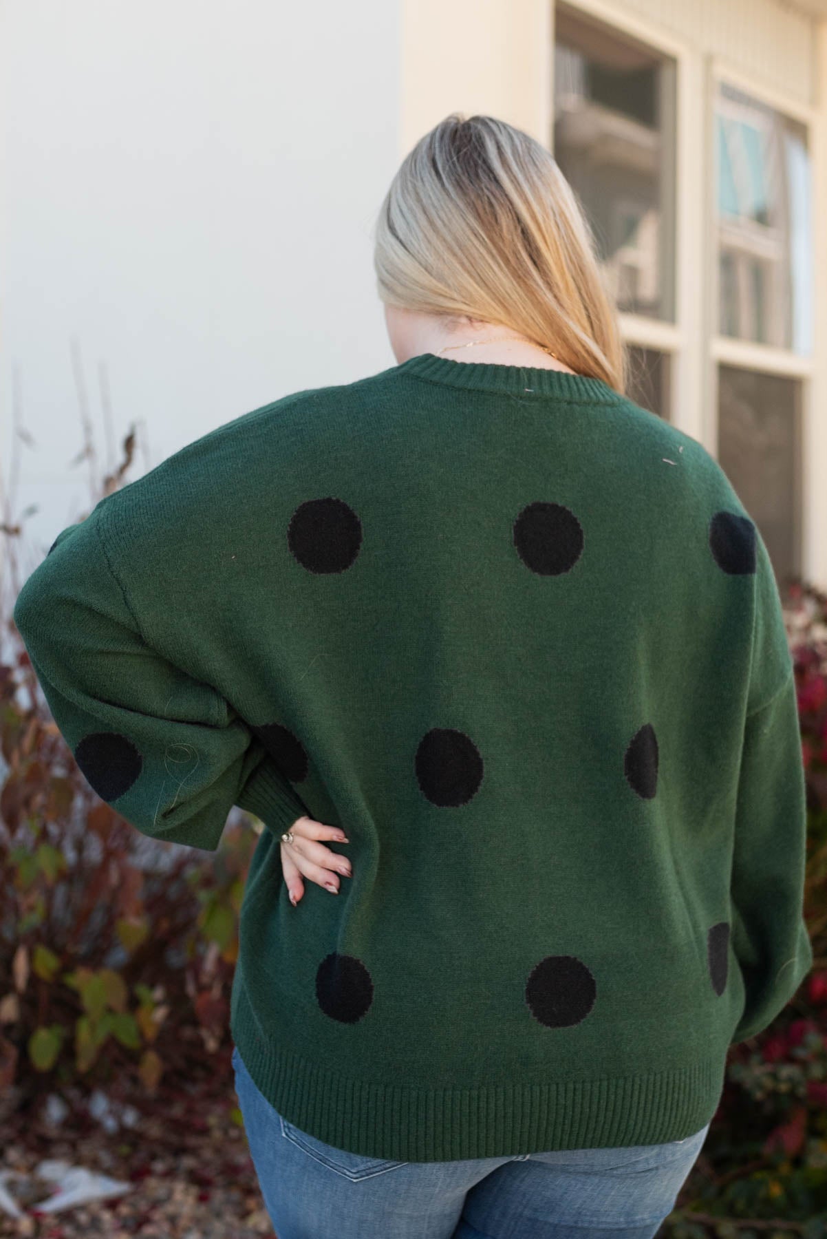 Back view of a plus size green poka dot sweater