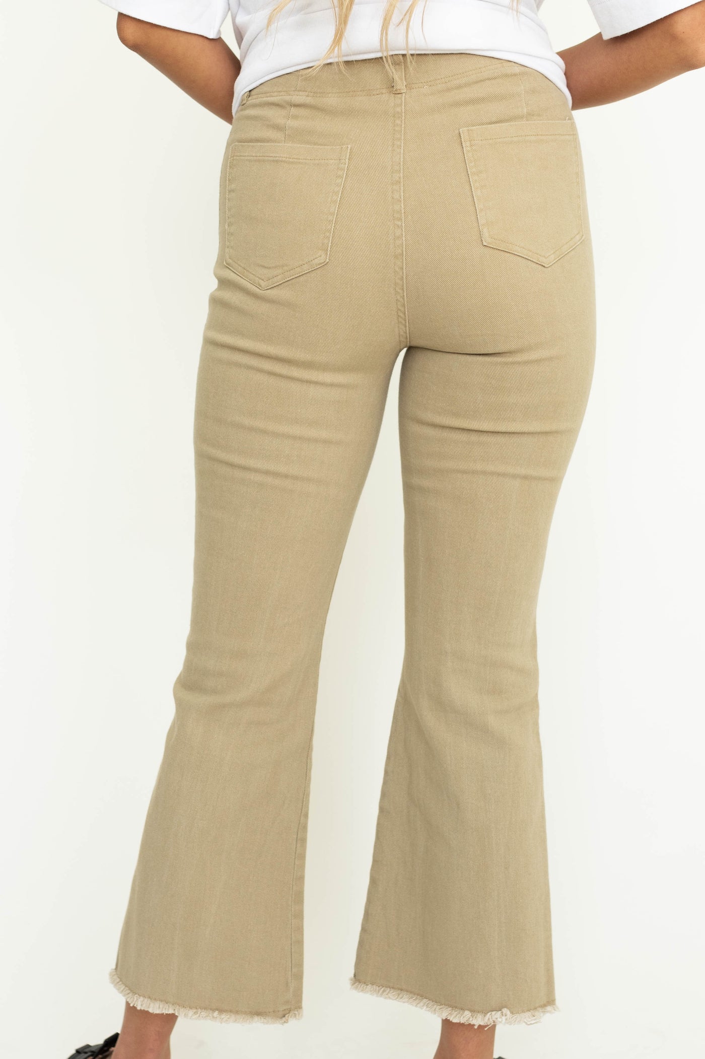 Back view of tan straight leg frayed edge, ankle length pants