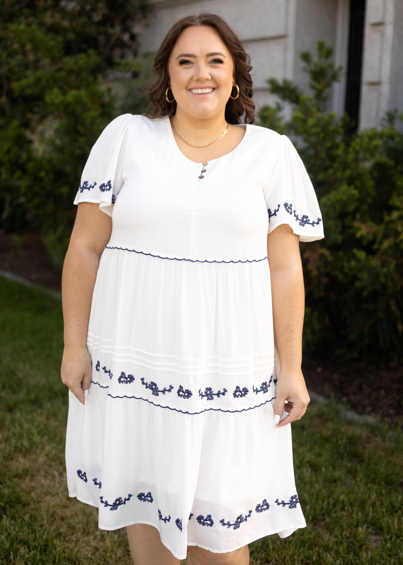 Plus size white dress with blue embroidery and buttons at the neck
