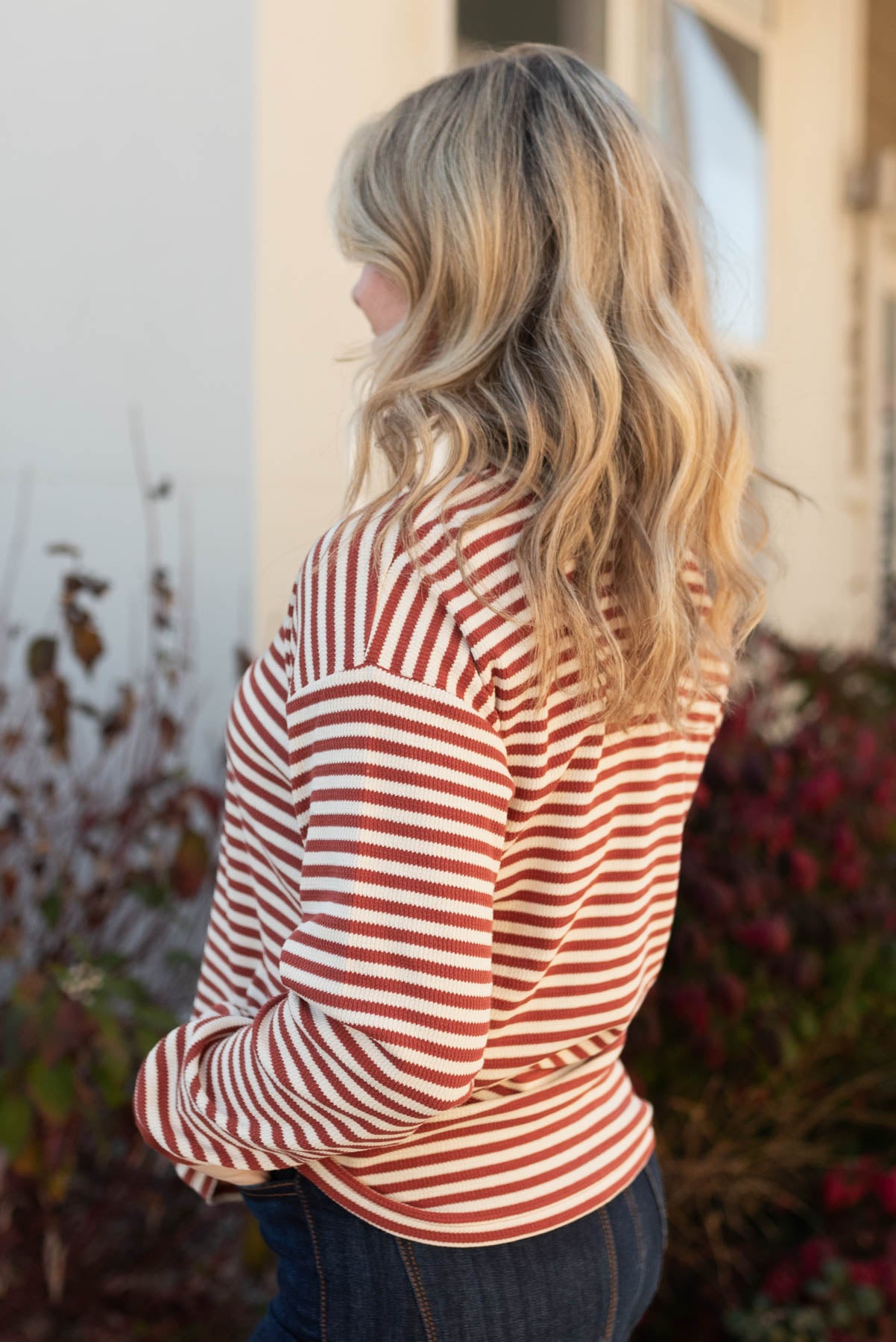 Side view of a rust striped top