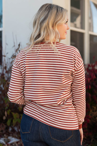 Back view of a long sleeve rust striped top