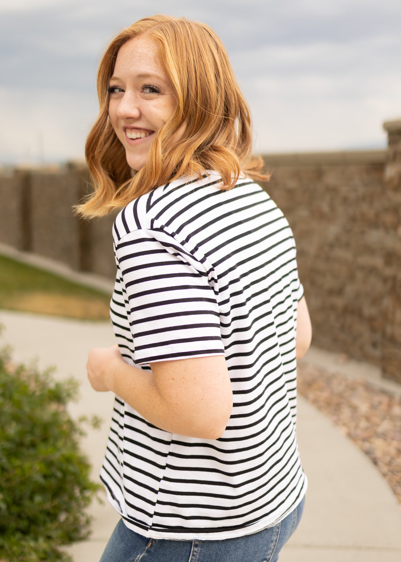 Side view of a short sleeve black top with stripes