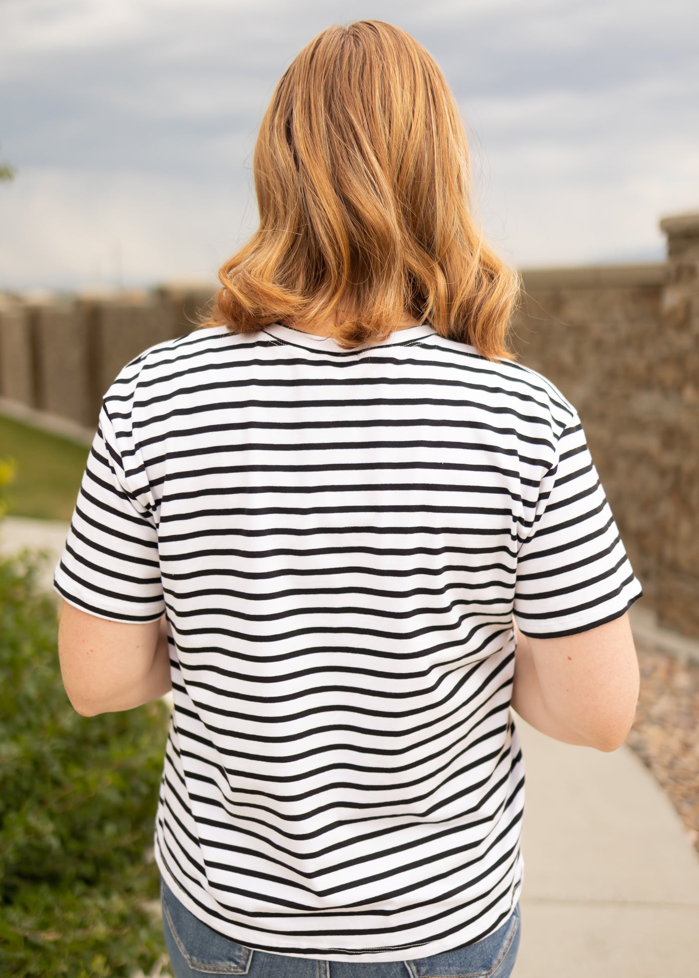 Back view of a short sleeve black top with stripes 