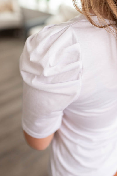 Close up of the sleeve on a white v neck puff sleeve top