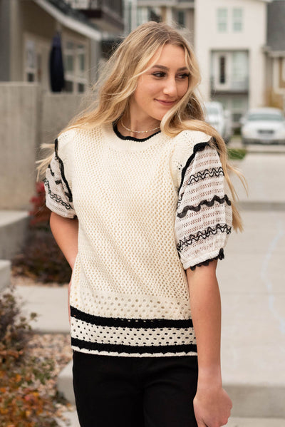 Cream puffed sleeve top with ruffle at the shoulder